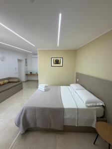 a bedroom with a large bed and a couch at Luxury Room Home Serpico in Scisciano