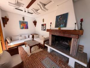a living room with a fireplace and a couch at Bright Riad with Panoramic Views - Oudayas in Rabat