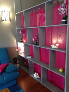 a book shelf with pink dividers in a living room at Studio charmant Le Moule 35m² + balcon in Le Moule