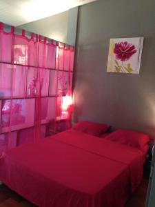 a bedroom with two beds with red sheets at Studio charmant Le Moule 35m² + balcon in Le Moule +8 photos