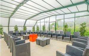 a room with chairs and tables in a building at Spacious villa in Florenville with private pool in Florenville