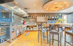 a large kitchen with blue cabinets and stools at Spacious villa in Florenville with private pool in Florenville +22 photos