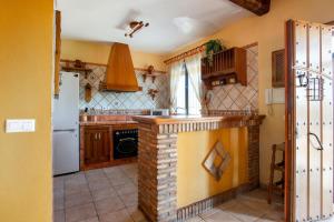 a kitchen with a brick counter and a refrigerator at Comfortable House in Carcabuey with Private Pool in Carcabuey +12 photos
