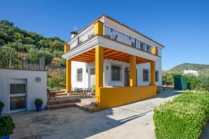 a yellow and white house with a balcony at Comfortable House in Carcabuey with Private Pool in Carcabuey
