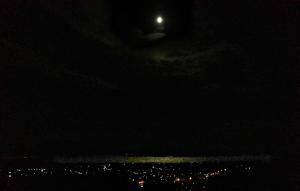 a moon in the sky over a city at night at Elegant Villa with Sea View in Politika in Politika
