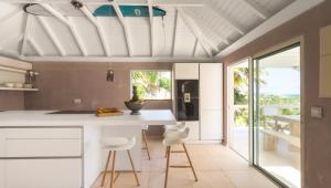 a kitchen with a white counter and stools at Heavenly Villa in Gustavia with Private Pool in Gustavia