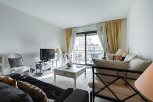 a living room with a couch and a table at Appartement de charme à Cannes + terrasse in Cannes