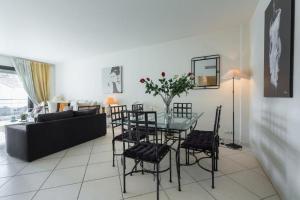 a living room with a glass table and chairs at Appartement de charme à Cannes + terrasse in Cannes