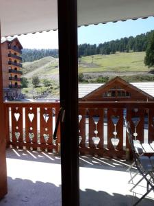 a view from the window of a house with a balcony at Appartement cosy à Pelinche, Risoul - 30m² in Risoul