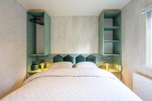 a bedroom with a large bed and green shelves at De Bosvlinder in Hoenderloo