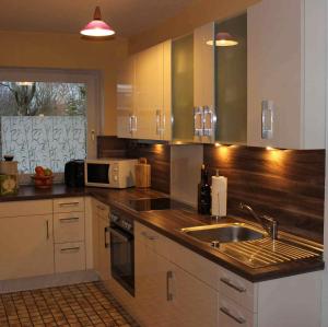 a kitchen with a sink and a microwave at Spacious House in Sylt-Ost, Garden in Tinnum
