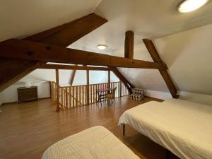 a attic room with two beds and a staircase at Cottage Normand in Lison
