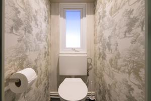 a bathroom with a toilet and a window at De Bosvlinder in Hoenderloo +32 photos