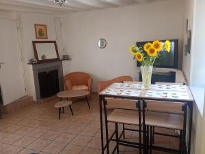 a living room with a table with a vase of flowers on it at La maisonnette Poyaudine in Toucy +7 photos