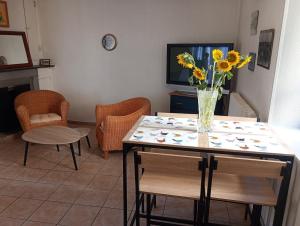 a living room with a table with a vase of flowers on it at La maisonnette Poyaudine in Toucy