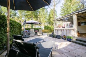 a patio with a table and chairs and an umbrella at De Bosvlinder in Hoenderloo