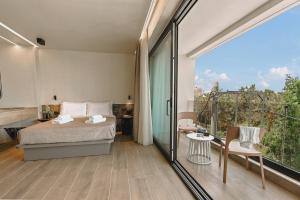a bedroom with a bed and a balcony at MAHA Her City Living by Semavί in Heraklio