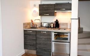 a kitchen with wooden cabinets and a sink at Appartement contemporain à Cognac, 50 m² - Parking. in Cognac
