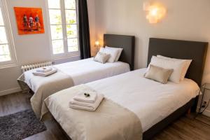 two beds in a room with white towels on them at Appartement contemporain à Cognac, 50 m² - Parking. in Cognac
