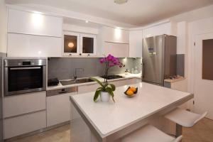 a kitchen with a table with a vase of flowers on it at Family Villa in Solin with Pool in Solin