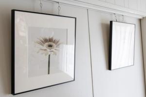 two framed pictures on a wall with a flower at HABi-Sekido5 in Wakayama