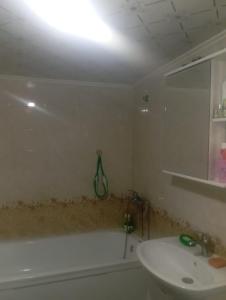 a bathroom with a white tub and a sink at Adelina in Kyzart