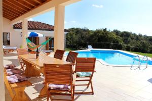 a patio with a table and chairs next to a pool at Charming Villa near Žminj with Private Pool in Žminj