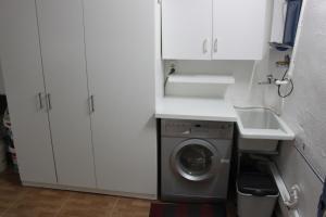 a white kitchen with a washing machine and a sink at Arrabal de San Benito II in Murcia