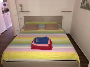 a bed with a colorful blanket and two bags on it at Cozy house in Chieti with private garden in Chieti