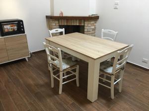a wooden table and chairs in a room with a fireplace at Cozy house in Chieti with private garden in Chieti