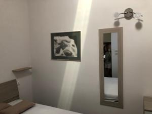 a mirror on a wall next to a bed at Cozy house in Chieti with private garden in Chieti +22 photos