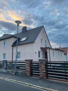 a white house with a fence and a street light at Apartment Kuhl in Selb
