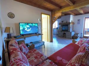 a living room with a couch and a flat screen tv at Appartement chaleureux à Soultzeren avec vue sur montagne in Soultzeren