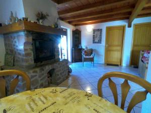 a living room with a fireplace and a table and chairs at Appartement chaleureux à Soultzeren avec vue sur montagne in Soultzeren