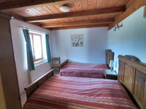 a bedroom with two beds and a window at Appartement chaleureux à Soultzeren avec vue sur montagne in Soultzeren +25 photos
