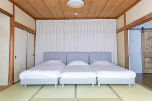 a bedroom with two beds with white sheets at HABi-Sekido5 in Wakayama