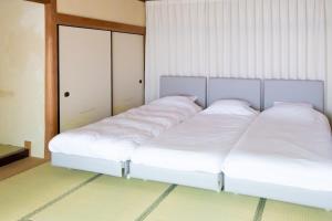 two beds in a room with white sheets at HABi-Sekido5 in Wakayama +27 photos