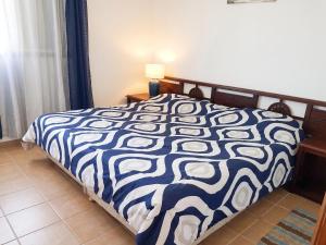 a bedroom with a bed with a blue and white comforter at Charming Apartment in La Savane - 65 m² - Terrace with View in Happy Bay