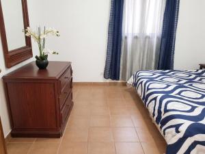 a bedroom with a bed and a dresser with a vase on it at Charming Apartment in La Savane - 65 m² - Terrace with View in Happy Bay