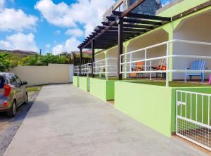 a building with green and white paint at Charming Apartment in La Savane - 65 m² - Terrace with View in Happy Bay