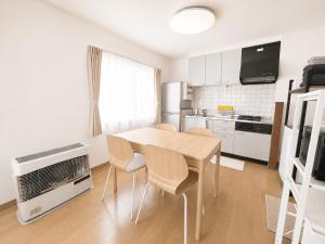a kitchen with a table and chairs in a room at 美瑛Stay in Biei