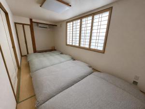 two beds in a room with two windows at 美瑛Stay in Biei