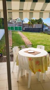 a table and chairs on a patio with a view of a field at Appartement charmant à Baie Mahault avec belle terrasse – 30 m² in Baie-Mahault