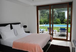 a bedroom with a bed and a view of a pool at "Spacious villa in Caniçada with year-round private pool" in Caniçada