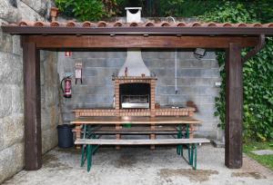 a picnic table with a fireplace in a stone wall at "Spacious villa in Caniçada with year-round private pool" in Caniçada
