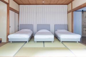 two beds in a room with white sheets at HABi-Sekido5 in Wakayama