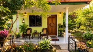 a front porch of a house with chairs and plants at The Nilmini Lodge in Sigiriya