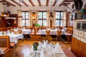 a restaurant with white tables and chairs and windows at Hotel-Restaurant & Metzgerei Rößle in Dettingen an der Erms