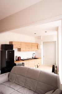 a living room with a couch and a kitchen at Le nid bourbourgeois in Bourbourg