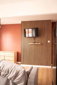 a bedroom with a flat screen tv on a wall at Le nid bourbourgeois in Bourbourg